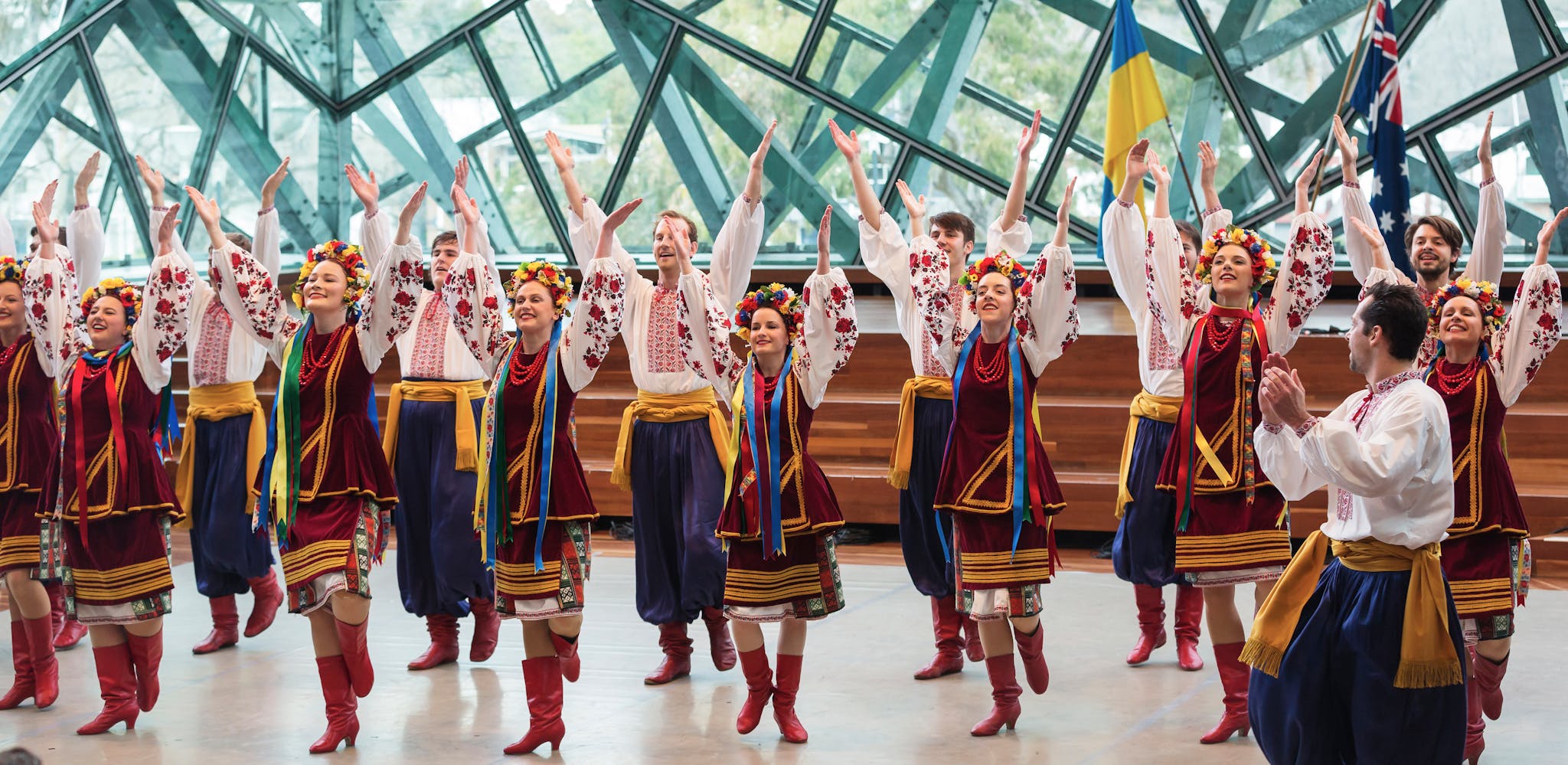 Energetic group performing Ukrainian folk dance with traditional attire indoors.