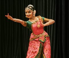 A skilled dancer performing Bharatanatyam in traditional attire on stage.
