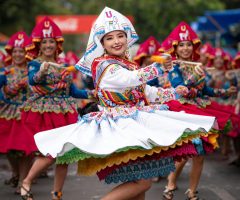 Joyful dancers in vibrant traditional costumes perform outdoors, creating a festive atmosphere.