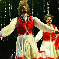 Vibrant dance performance with traditional costumes on stage, capturing dynamic motion and cultural expression.